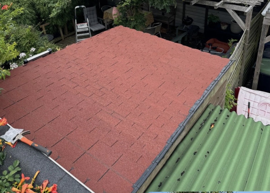 Nieuwe rode shingles op een dak in een tuin